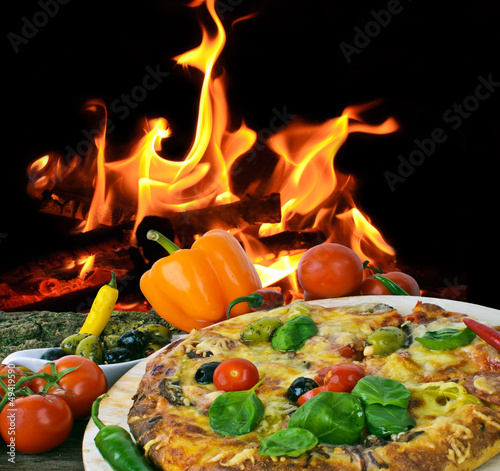 Pizza, gebacken in Holzkohleofen, vor offenem Feuer
