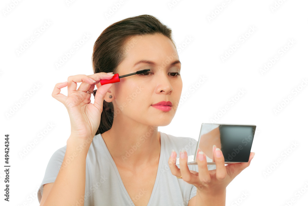 Isolated Asian woman applying mascara on white. Isolated Asian woman applying mascara on white.