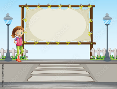 A girl beside a blank signage in the street