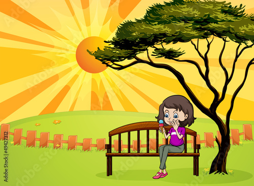 A girl in the park sitting in the wooden bench
