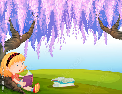 A girl reading a book at the park