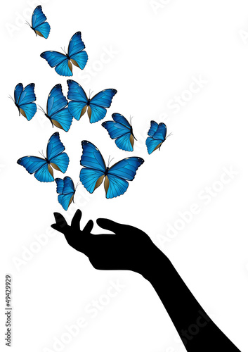 Mano con volo di farfalle blu photo