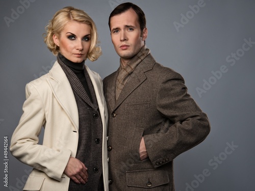 Elegant couple in coats isolated on grey © Nejron Photo