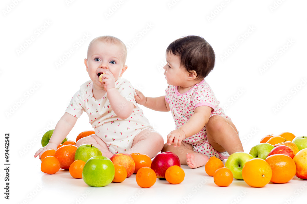 Funny kids babies eating healthy food fruits isolated on white b Funny kids babies eating healthy food fruits isolated on white b