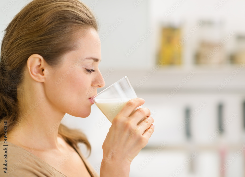 Young woman drinking milk in kitchen Young woman drinking milk in kitchen