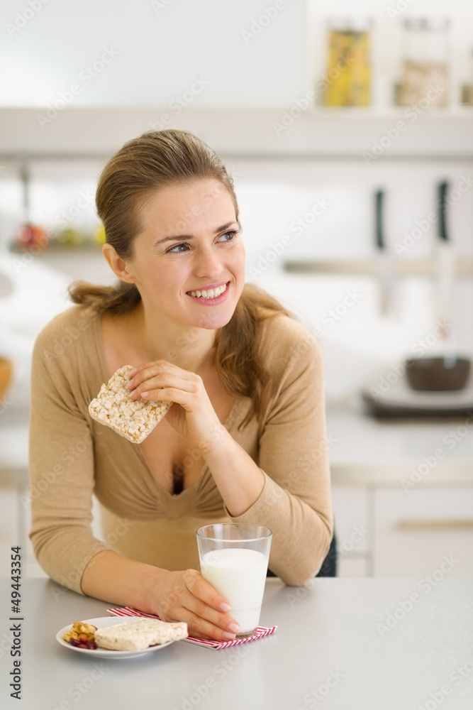 Young woman eating snacks in modern kitchen Young woman eating snacks in modern kitchen