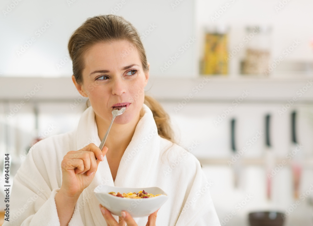 Happy young woman in bathrobe eating healthy breakfast Happy young woman in bathrobe eating healthy breakfast