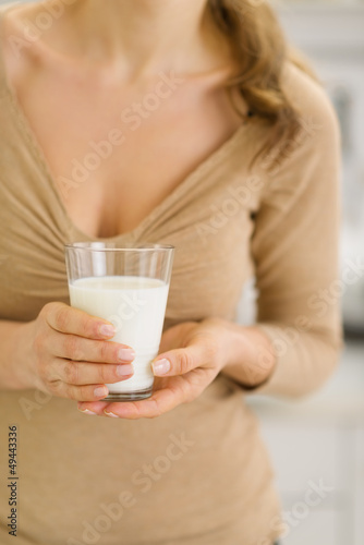 Closeup on glass of milk in hand of young woman © Alliance
