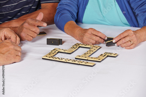 Hände von Senioren beim Dominospiel