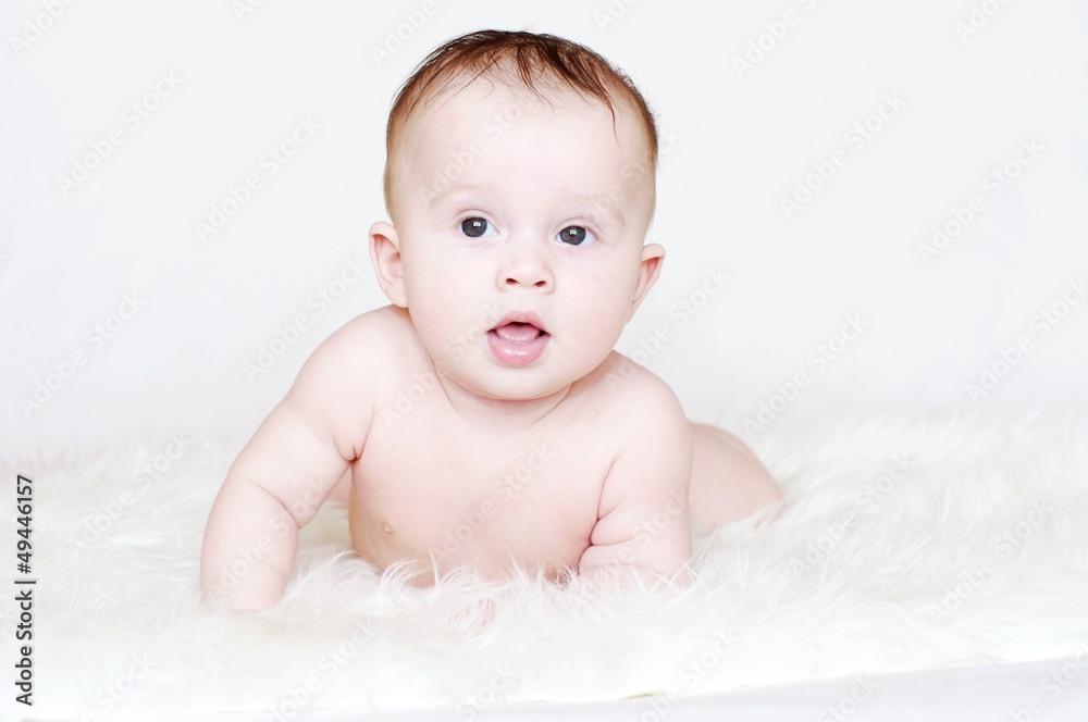 Portrait of the amusing four-months baby lying on a stomach Portrait of the amusing four-months baby lying on a stomach