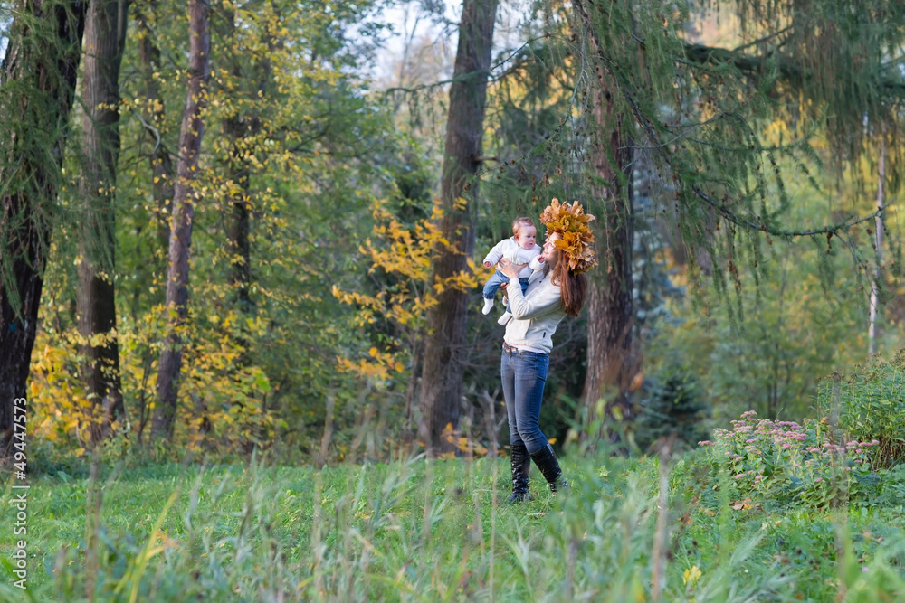 Beautiful woman and a baby girl walking in a forest