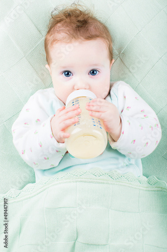 Beautiful little baby with a milk bottle