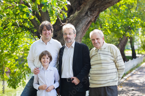 Four generations of men standing in a park © famveldman