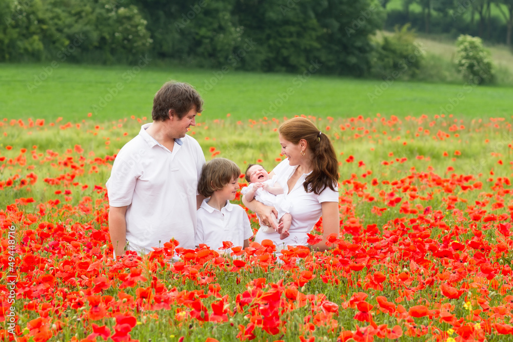 Happy family with son and a newborn poppy flower field Happy family with son and a newborn poppy flower field