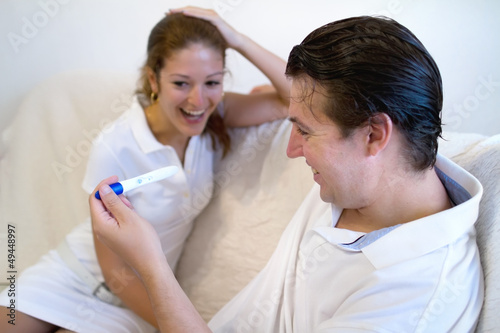 Young couple excited holding positive pregnancy test