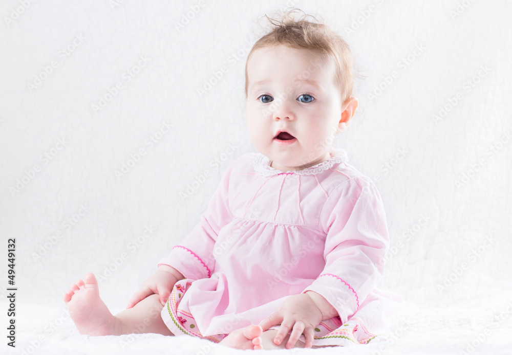 Beautiful baby girl in a pink dress on a white background Beautiful baby girl in a pink dress on a white background