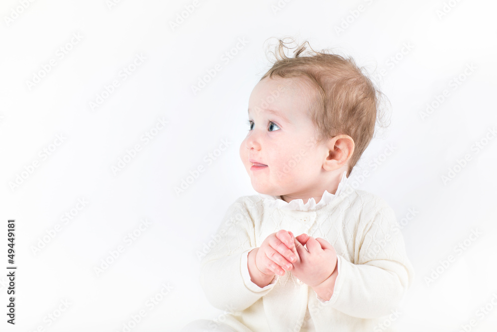 Profile of a cute baby girl in a white knitted cardigan Profile of a cute baby girl in a white knitted cardigan