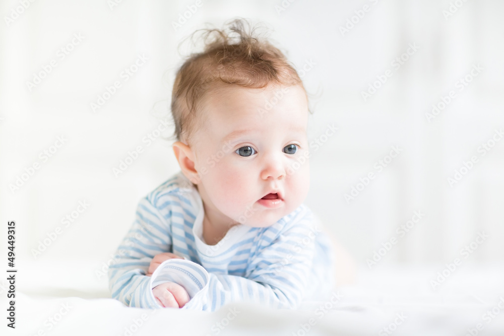 Adorable baby doing her tummy time in a white nursery Adorable baby doing her tummy time in a white nursery