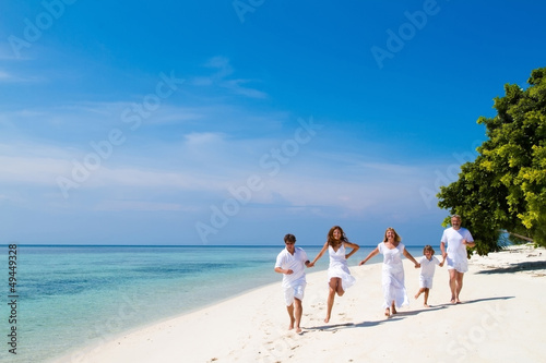 Family celebrating running on beautiful tropical beach