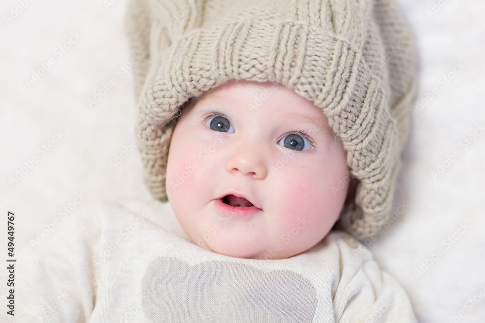 Baby in a huge knitted hat looking surprised Baby in a huge knitted hat looking surprised