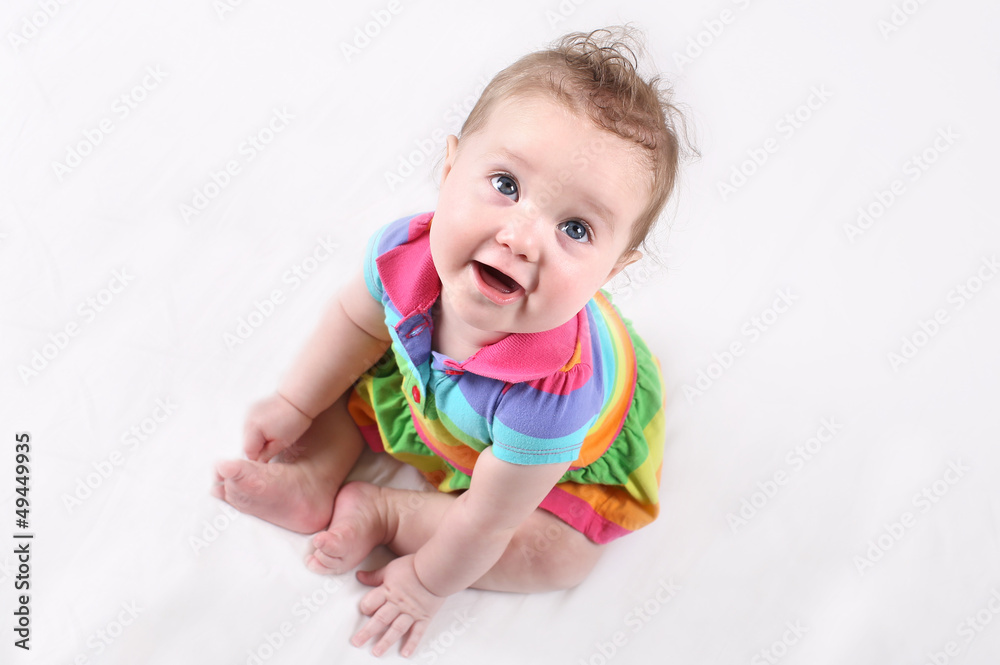 Funny happy baby in a colorful striped dress Funny happy baby in a colorful striped dress