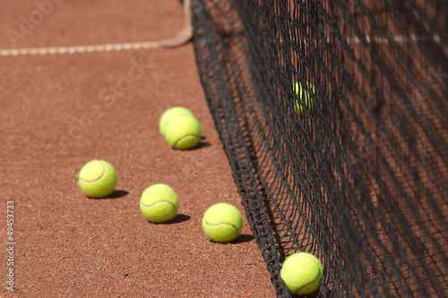Ground court with yellow tennis balls before net closeup © DyMaxFoto