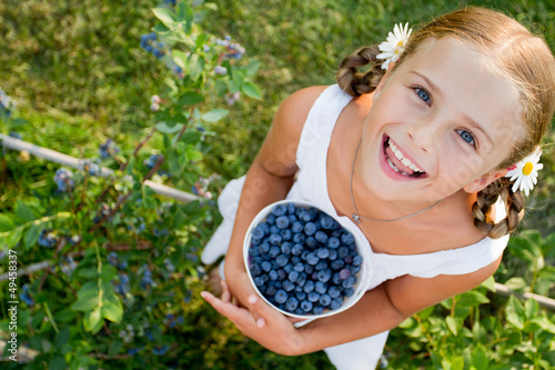 Obraz na płótnie Blueberries - Girl with ripe blueberries in the garden w salonie