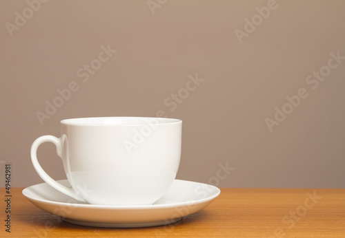 White cup and saucer on wooden table