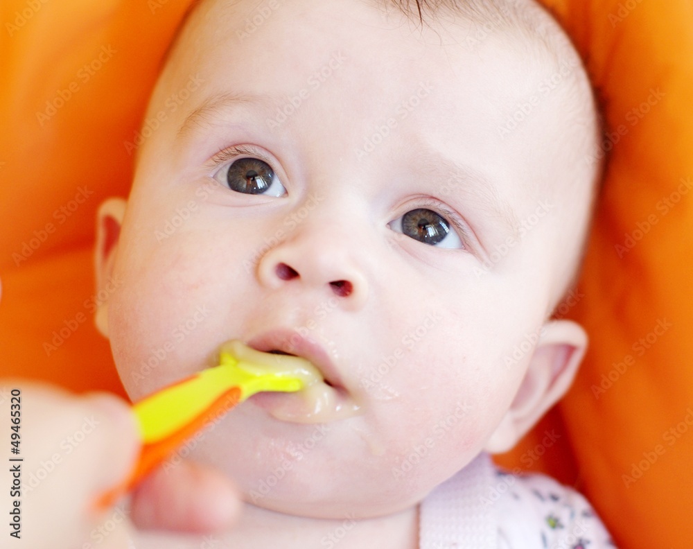 The five-months baby is fed by puree from a spoon The five-months baby is fed by puree from a spoon