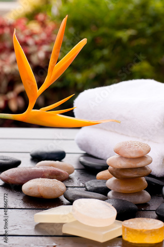 Outdoor spa with zen stones and soaps on a wooden deck
