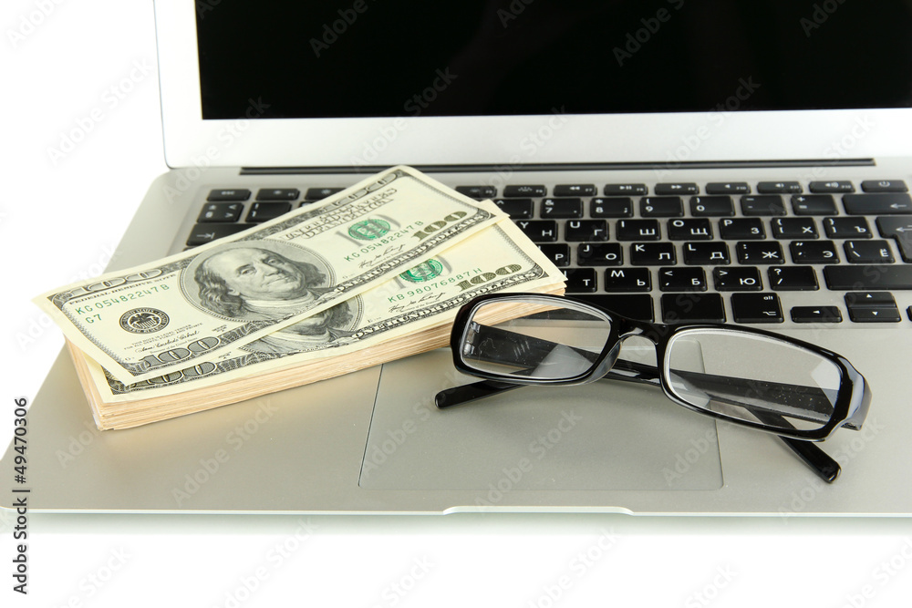 Money with glasses on laptop isolated on white Money with glasses on laptop isolated on white