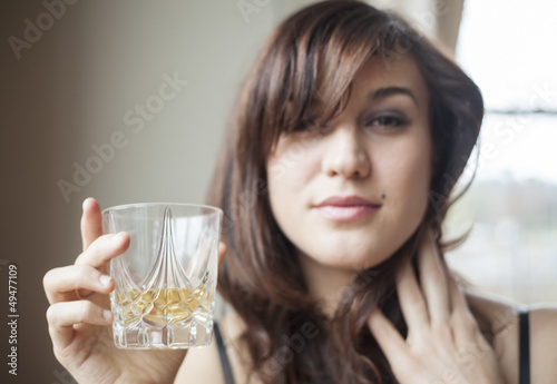 Fotografie Young Woman in Lingerie Drinking Scotch