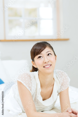 Free Download Beautiful asian woman relaxing in bedroom - GFXLoad