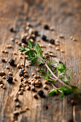 Assorted spices and thyme on wooden background