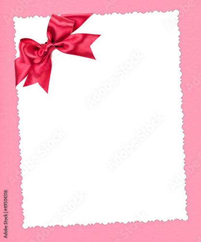 blank paper sheet with red bow on pink