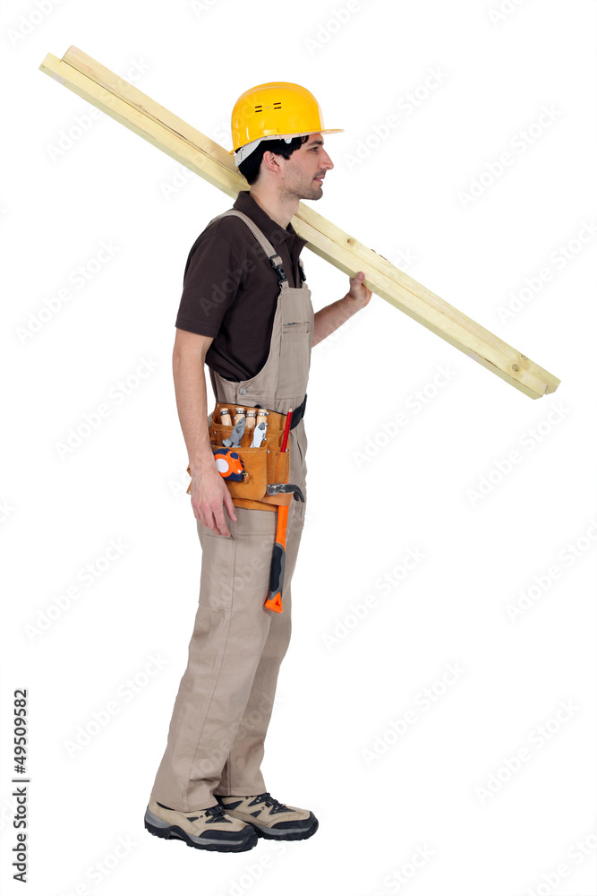 craftsman carrying two wooden boards on his shoulder