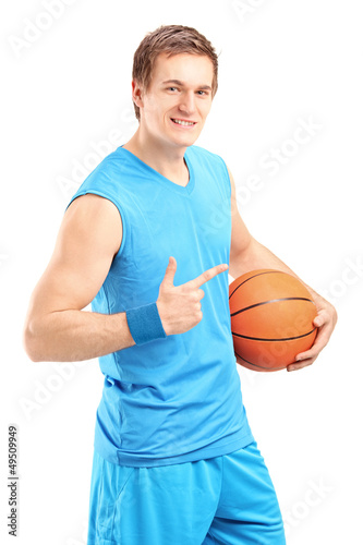 A smiling basketball player holding a ball and gesturing