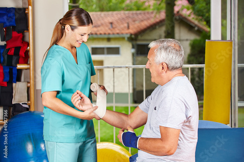 Krankenschwester bei Physiotherapie wechselt Verband photo