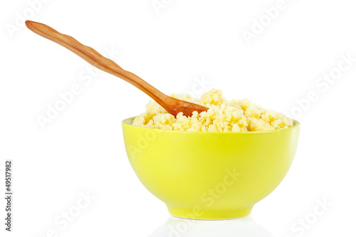 Green bowl with millet porridge and spoon isolated on white photo