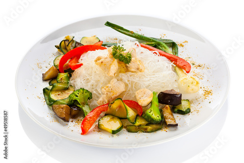 Roasted meat, rice noodles and vegetables on white background