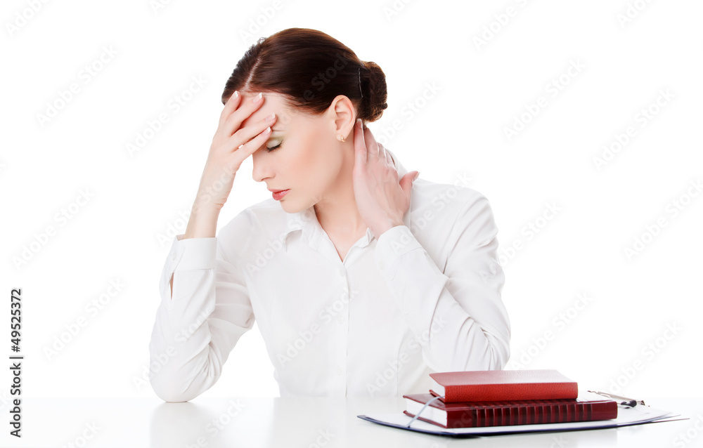 Tired young woman at a table with books, white background