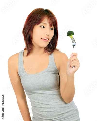 Isollated young asian woman with a piece of broccoli