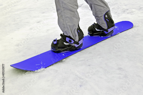 sportsman with blue snowboard on white snow, seasonal sport