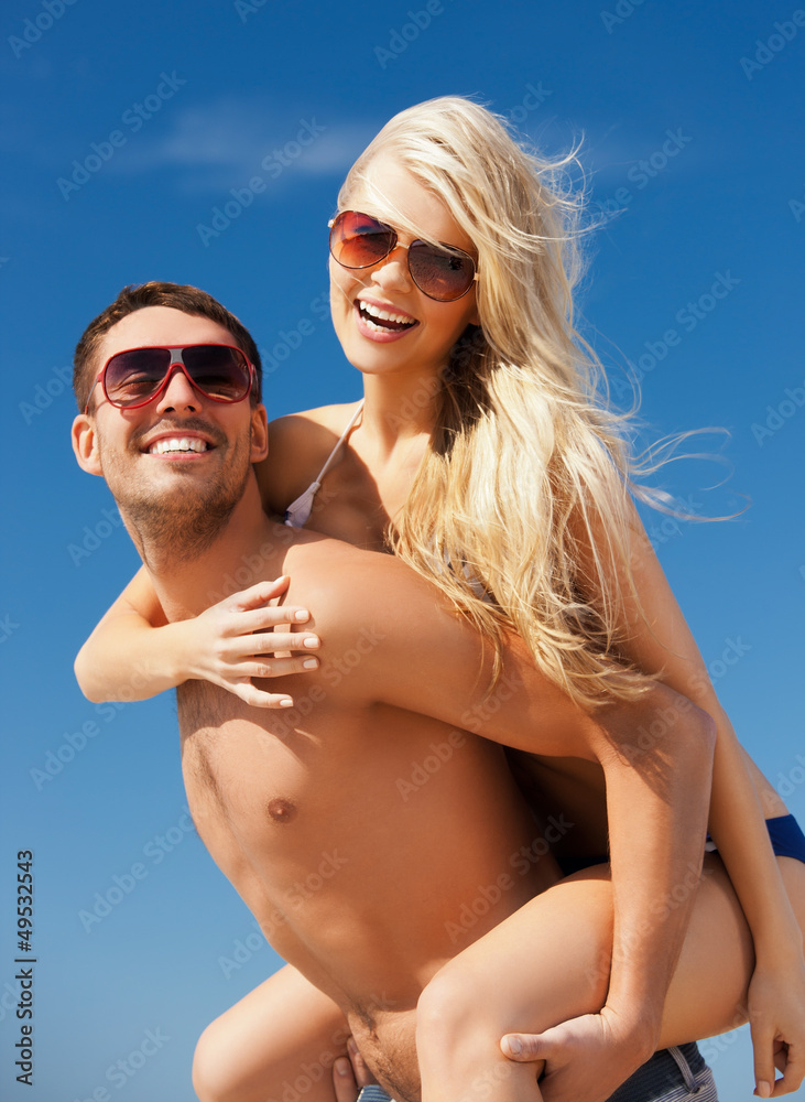 happy couple in sunglasses on the beach happy couple in sunglasses on the beach