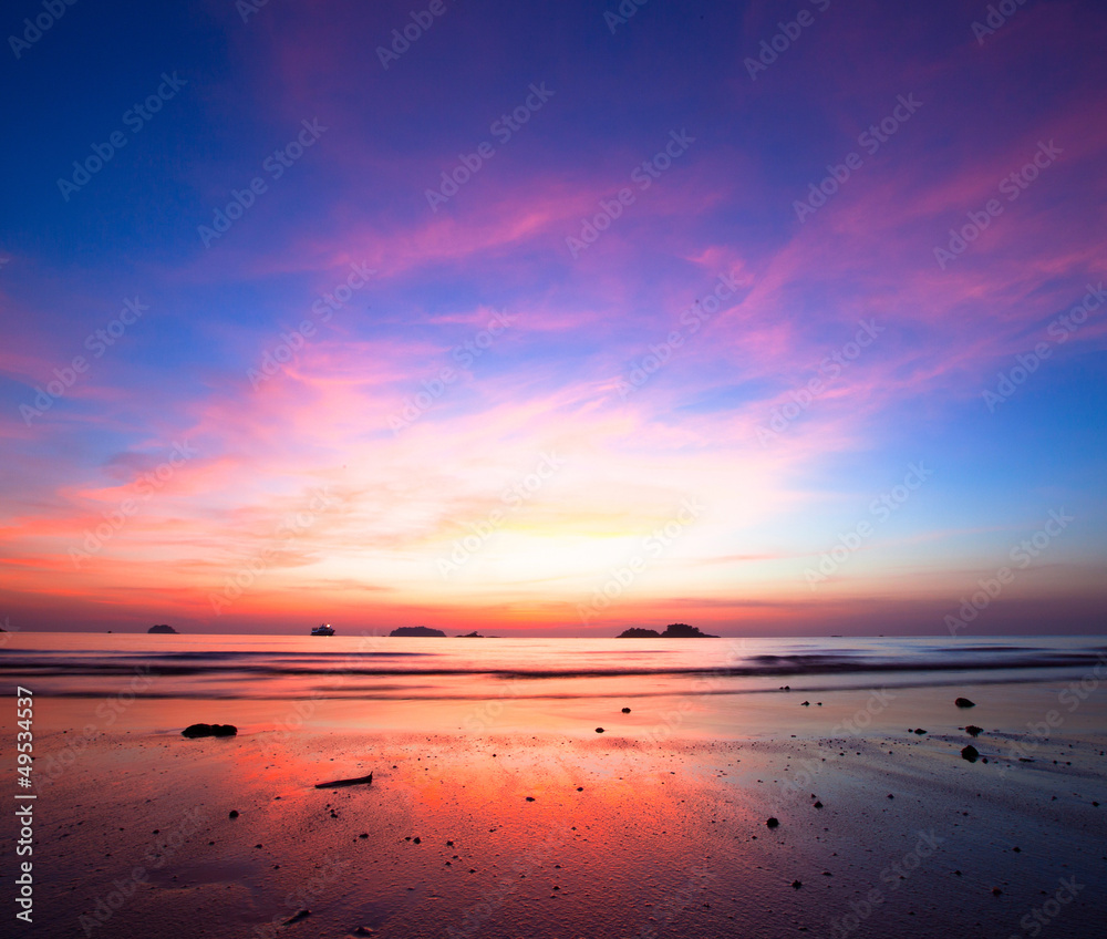 Sunset over ocean at low tide