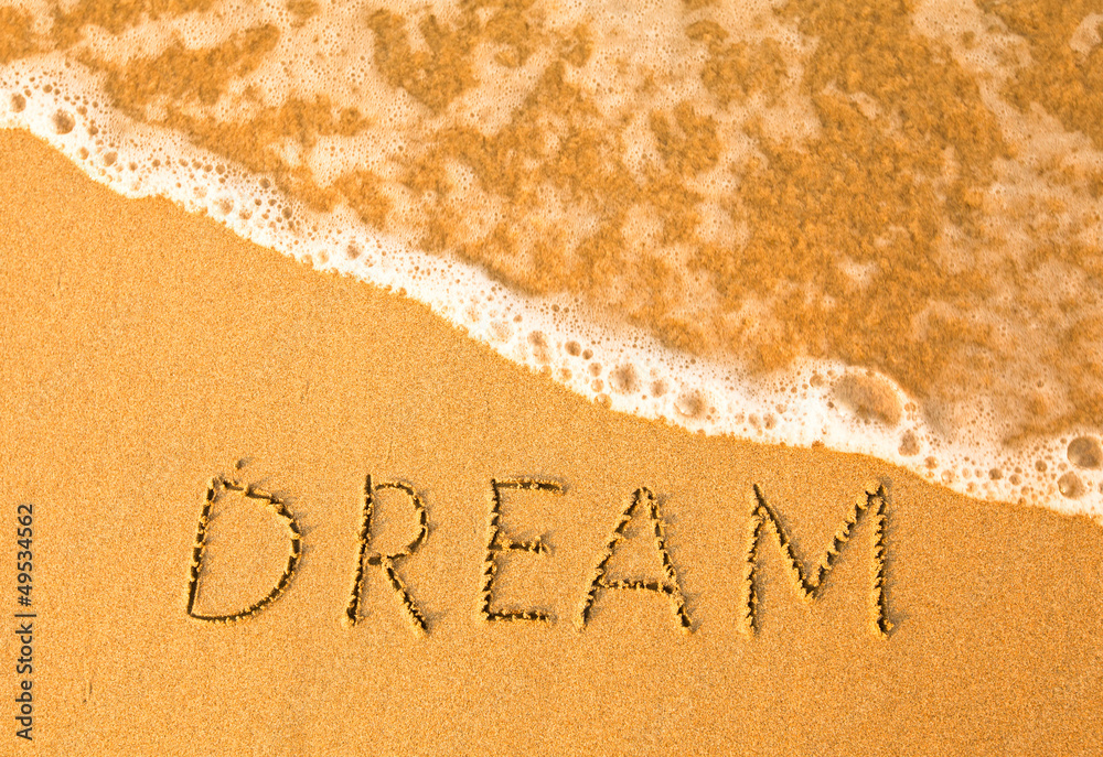 Fototapeta premium Dream, text written by hand in sand on a beach.