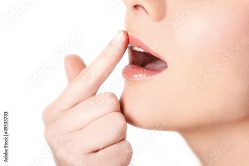 Frau cremt sich die Lippen ein photo