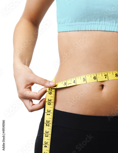 Young woman measuring her perfect waist. Close up
