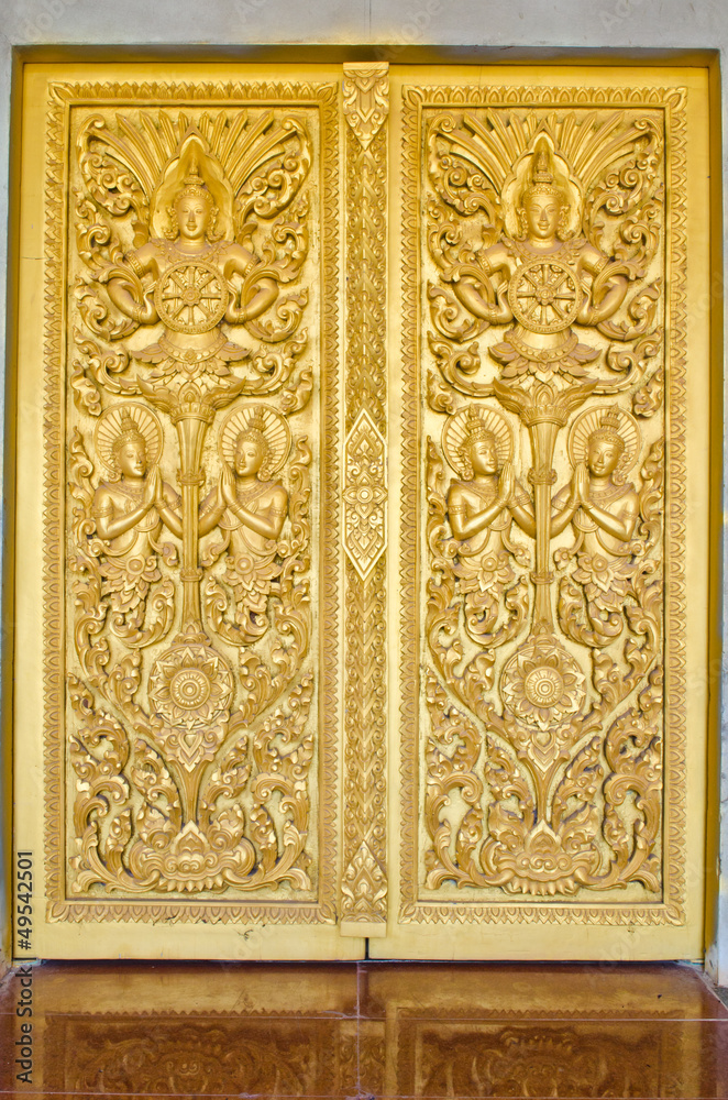 Golden Thai design craft on wooden door in temple of Thailand
