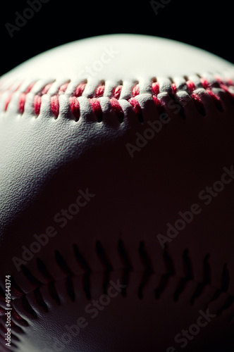 Canvas Print Vertical shot of a baseball ball over black background, macro